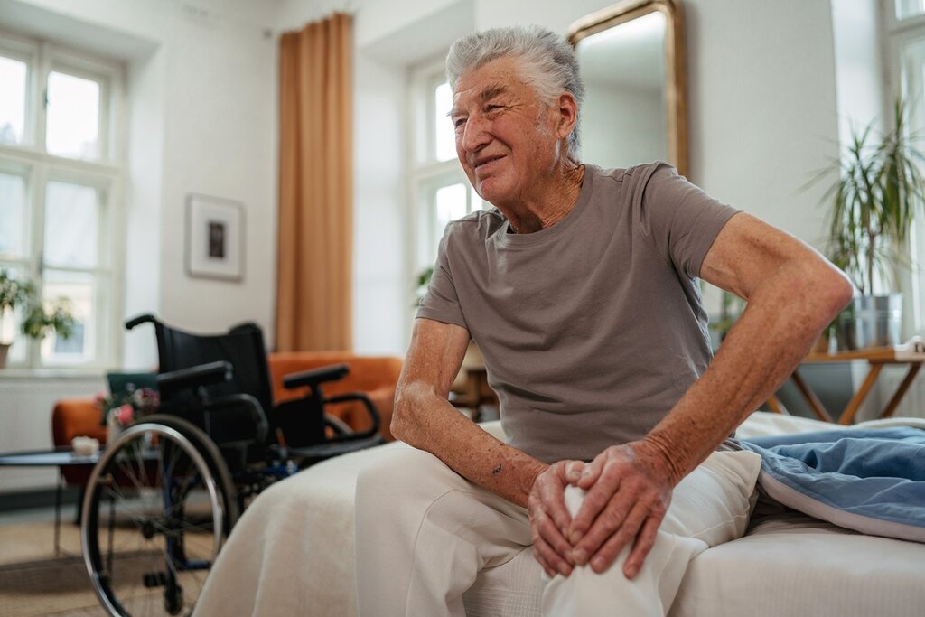 A man in a wheelchair in his bedroom